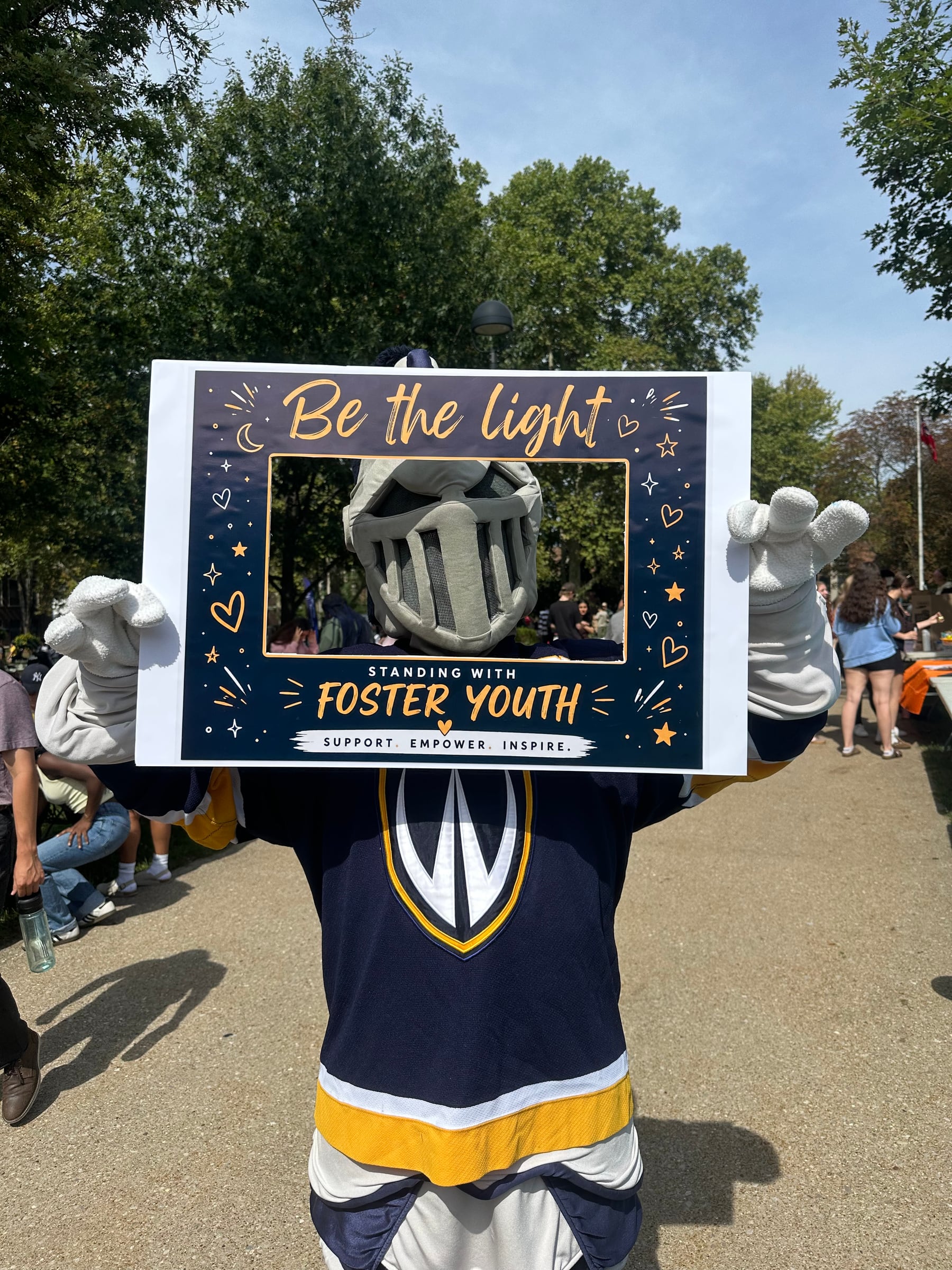 The University of Windsor Lancer mascot holding the Little Lights Be the Light frame